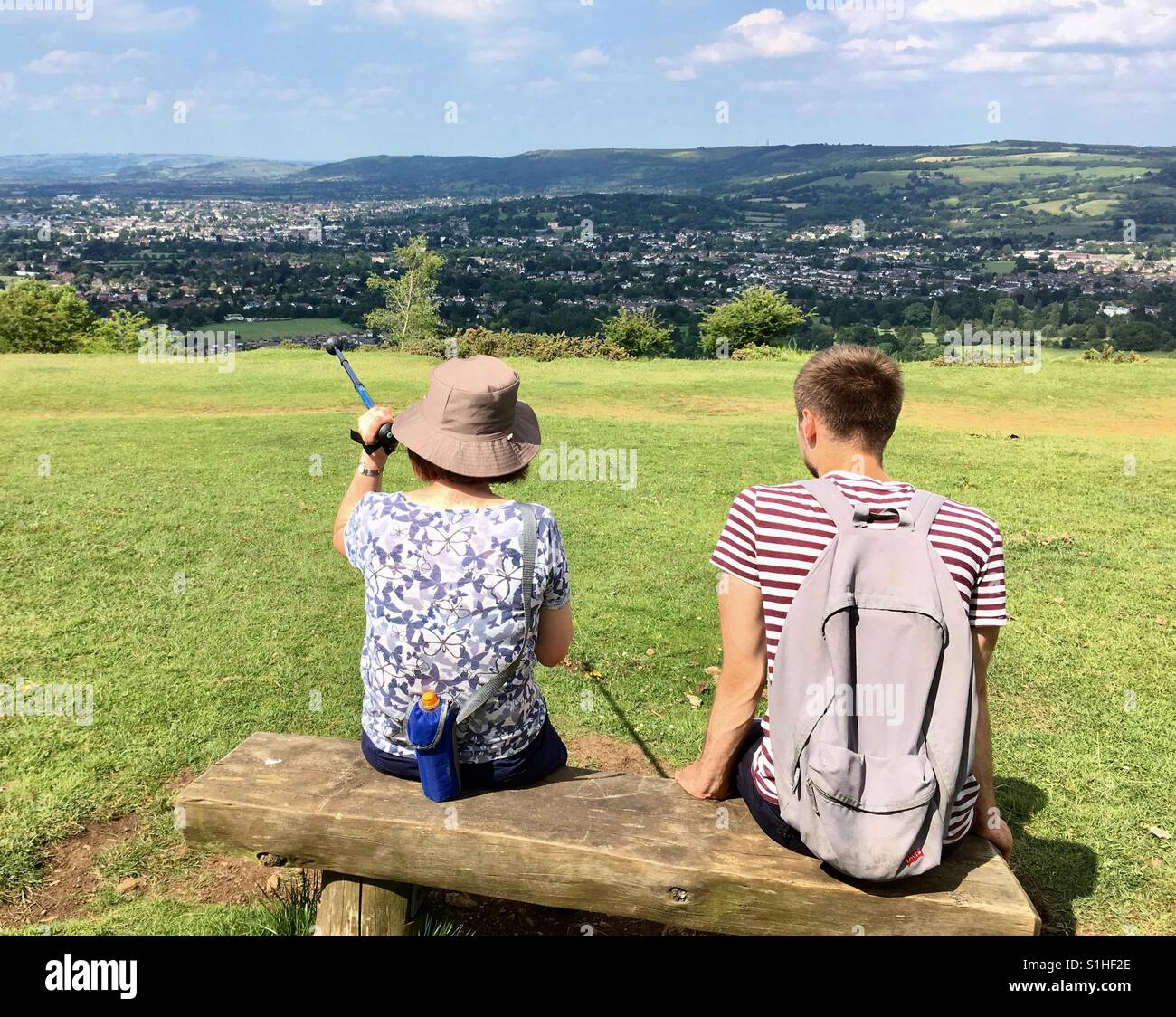 La mère et le fils assis sur le banc de la colline admiring view Banque D'Images