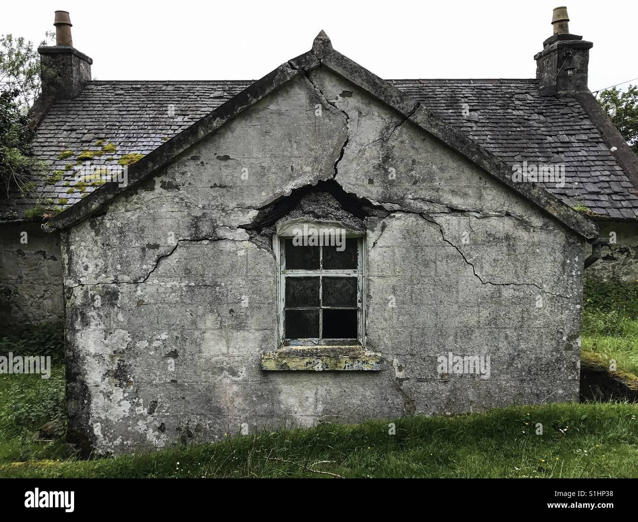 Des fissures dans la maçonnerie autour de la fenêtre d'une maison ancienne à distance sur l'île de Mull, en Ecosse. Banque D'Images