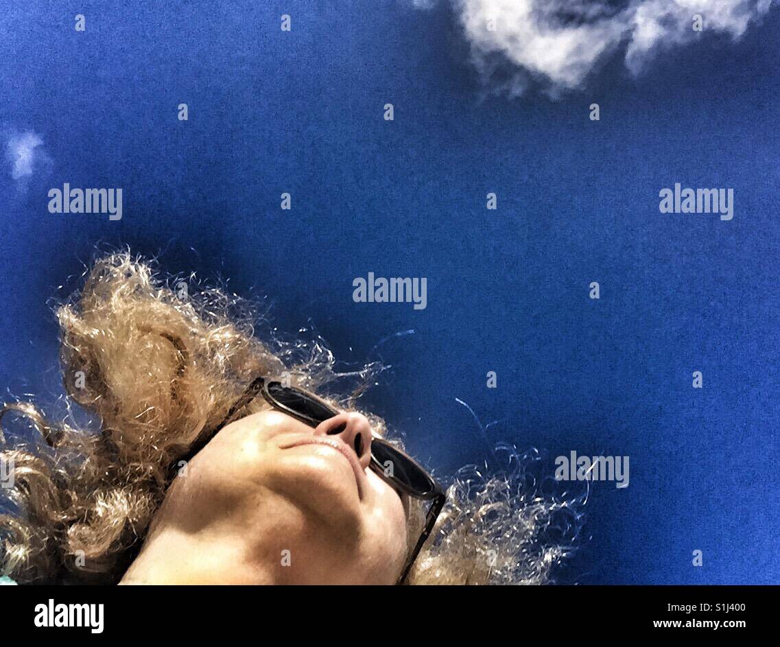 La photo d'une femme surréaliste à la recherche jusqu'au ciel bleu - Image de stock capturée avec un smartphone