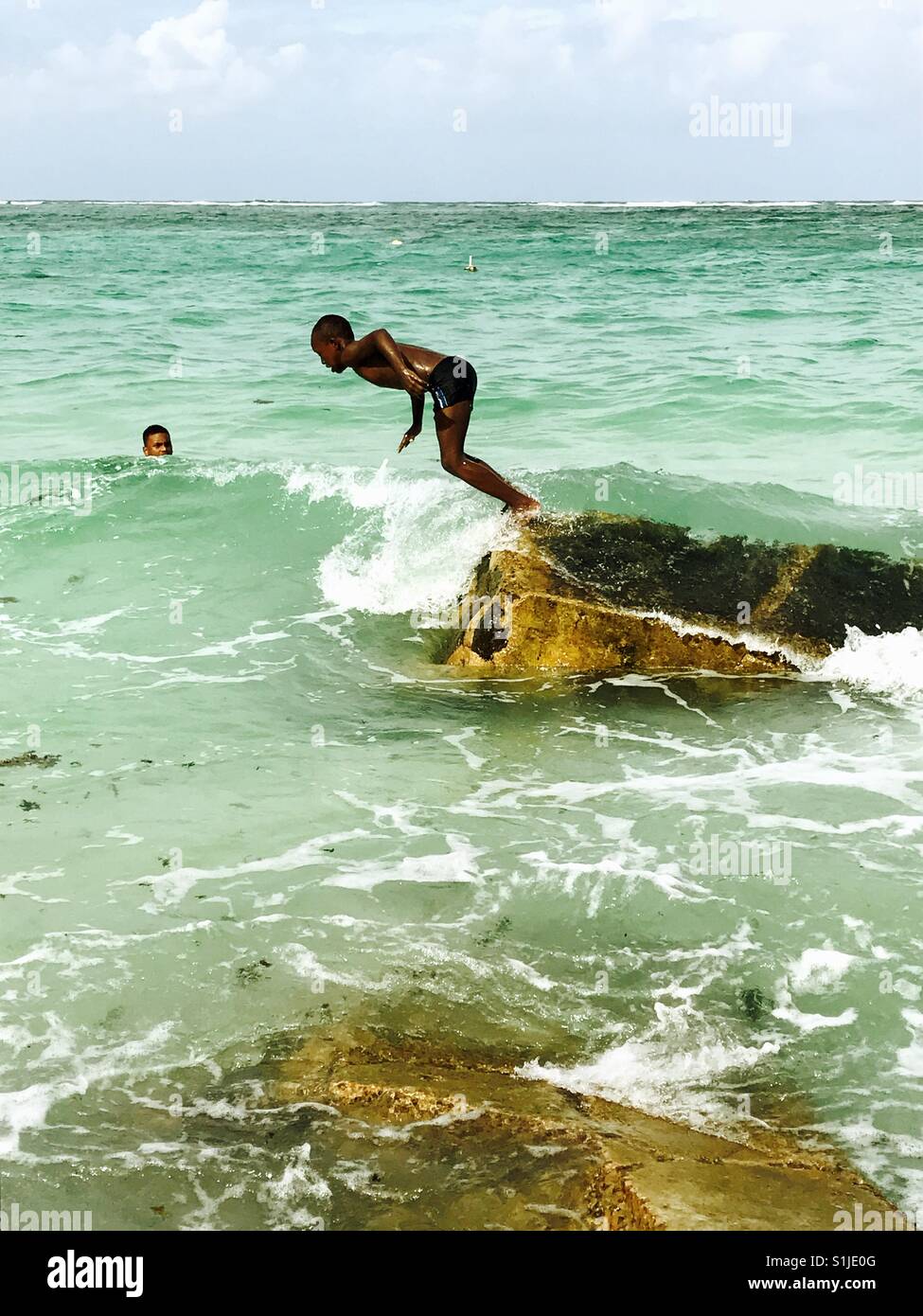 Les enfants de sauter dans l'eau, Mahe, Seychelles Banque D'Images