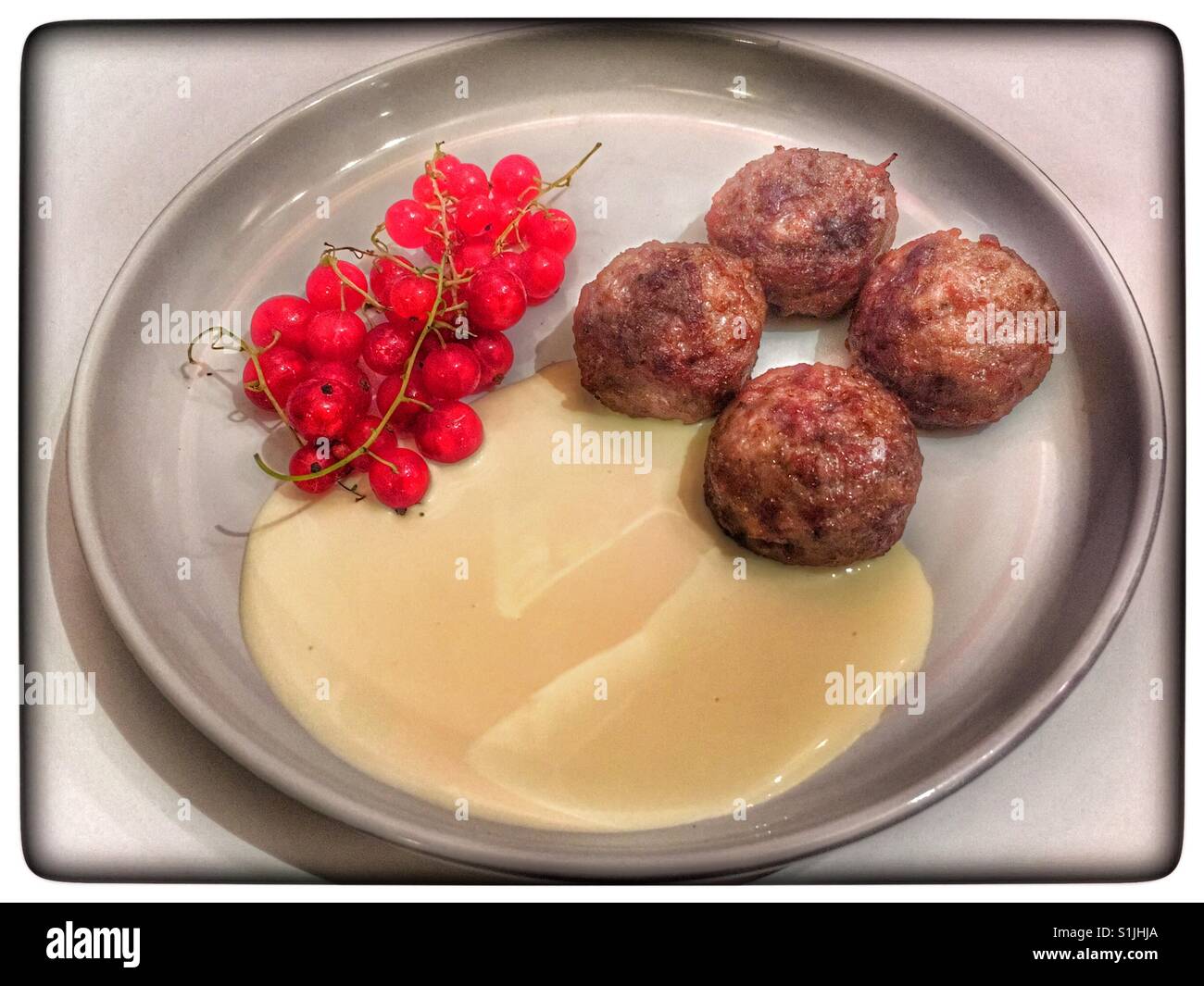 Boulettes de viande Wagyu avec groseille rouge et crème. Banque D'Images