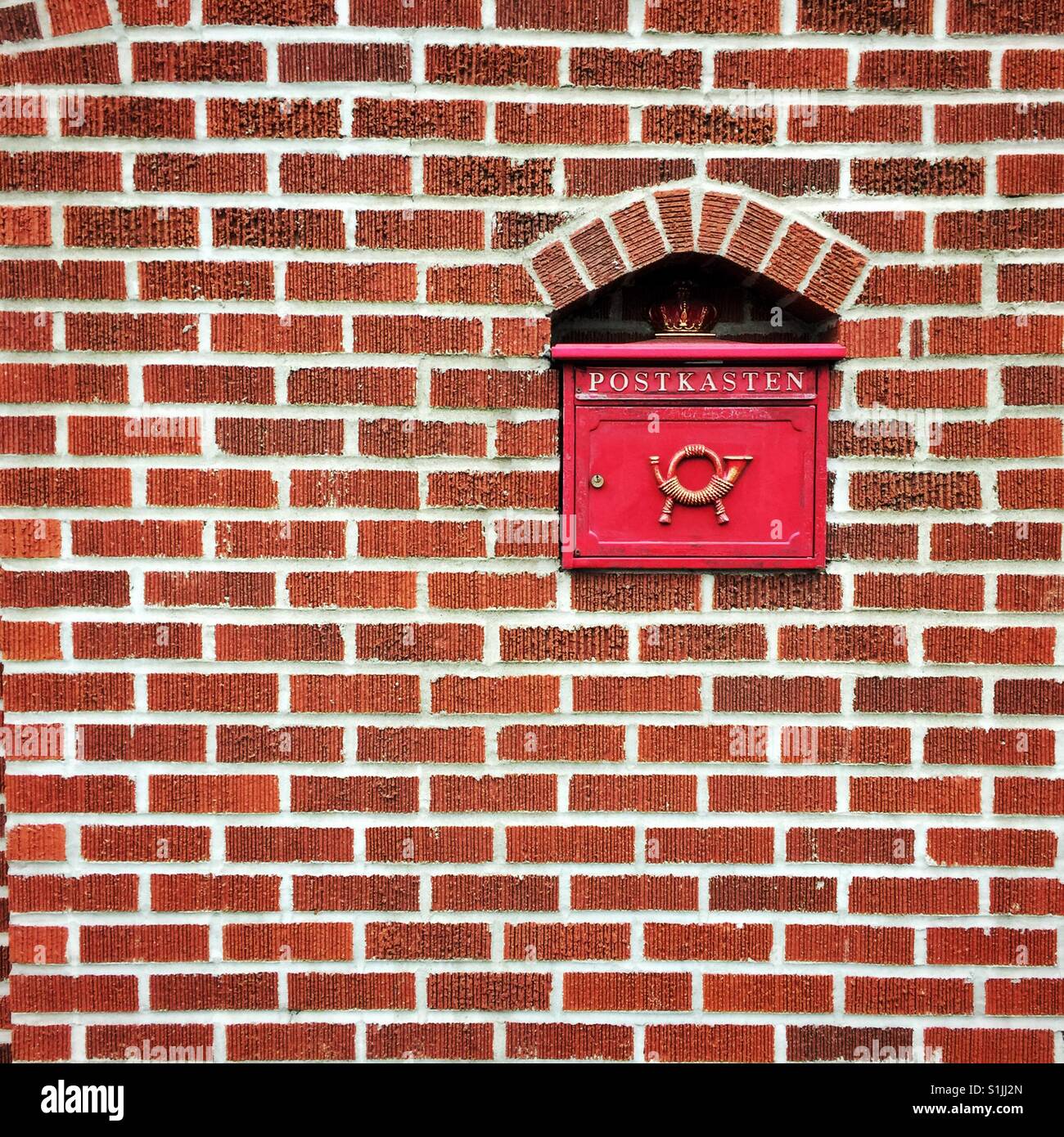 Letterbox vintage rouge avec word Postkasten et mur de brique à l'intérieur de l'avertisseur sonore dans le quartier de Georgetown à Seattle Banque D'Images