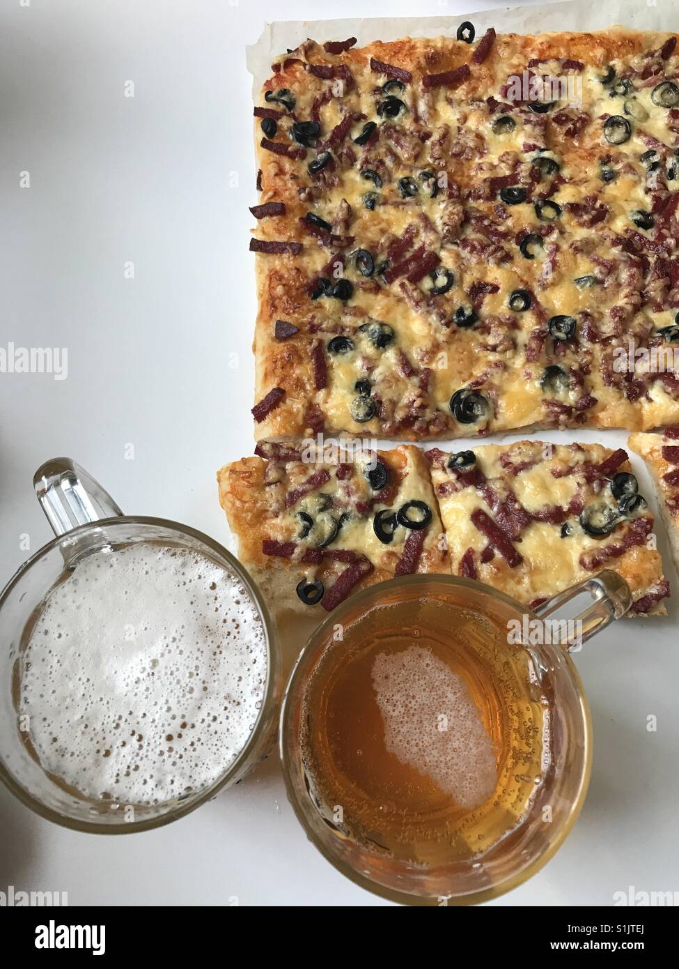 Prêt pizza, coupées en tranches et de la bière. Vue de dessus Banque D'Images