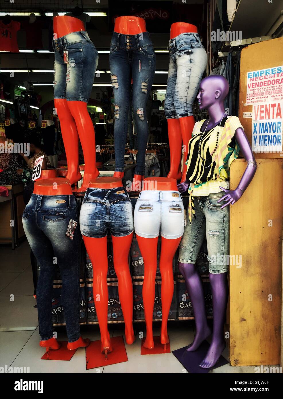 Les pattes orange et violet mannequin femme jeans bon marché modélisation vêtements à Lima, Pérou Banque D'Images