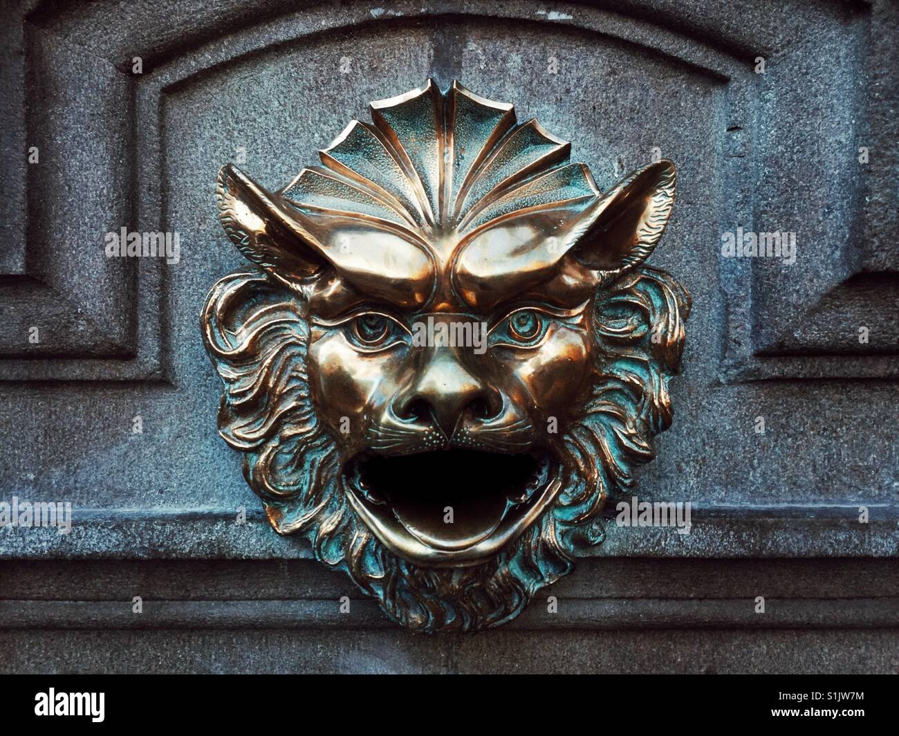 Feu de tête de lion en bronze décore mur de pierre de l'édifice à Lima, Pérou - Image de stock capturée avec un smartphone