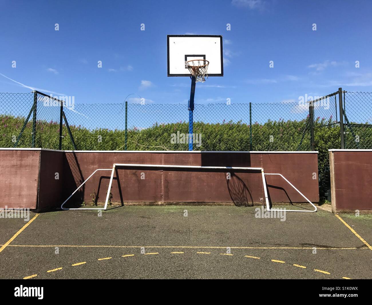 Un panier de basket-ball et un but de football sur un terrain de sport de la communauté en Angleterre. Banque D'Images