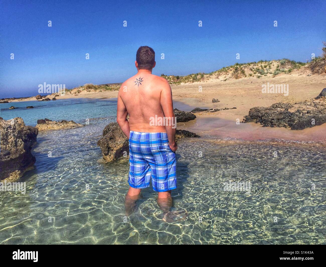 Vue arrière de l'homme debout en clair, l'eau de mer Banque D'Images