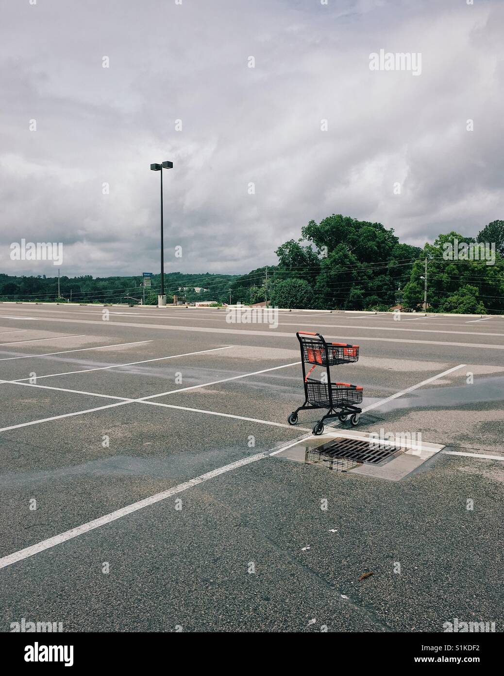 Lonely panier en bande stérile parking de centre commercial. Banque D'Images