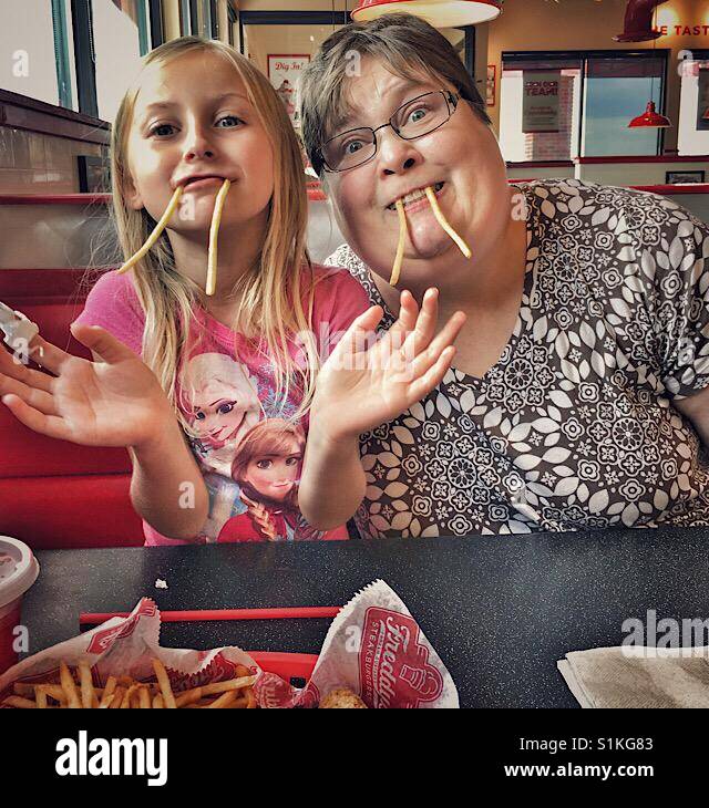Une fille et une femme se faisant passer pour les morses avec frites. Banque D'Images