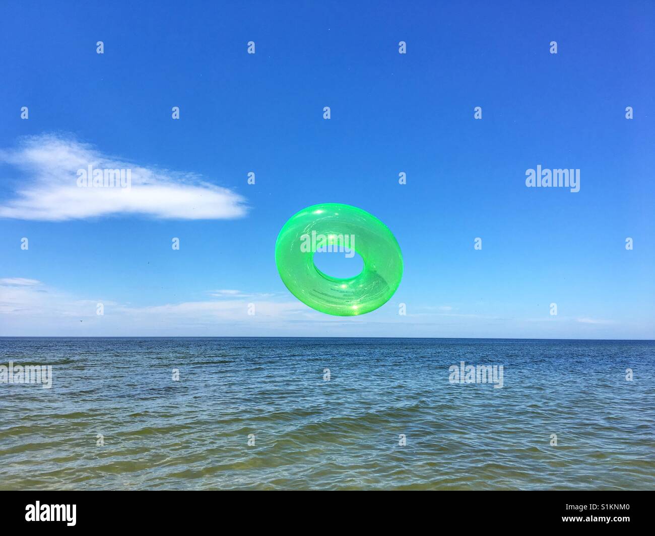 Cercle vert jouet gonflable dans l'air à la plage Banque D'Images