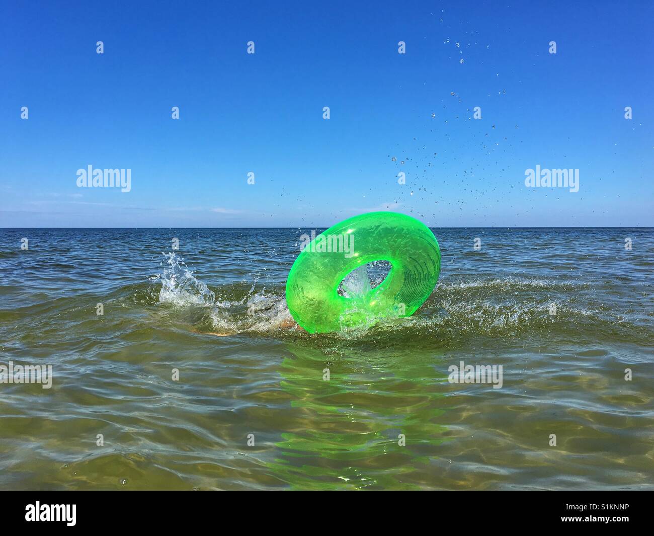 Cercle vert jouet gonflable dans la mer Banque D'Images