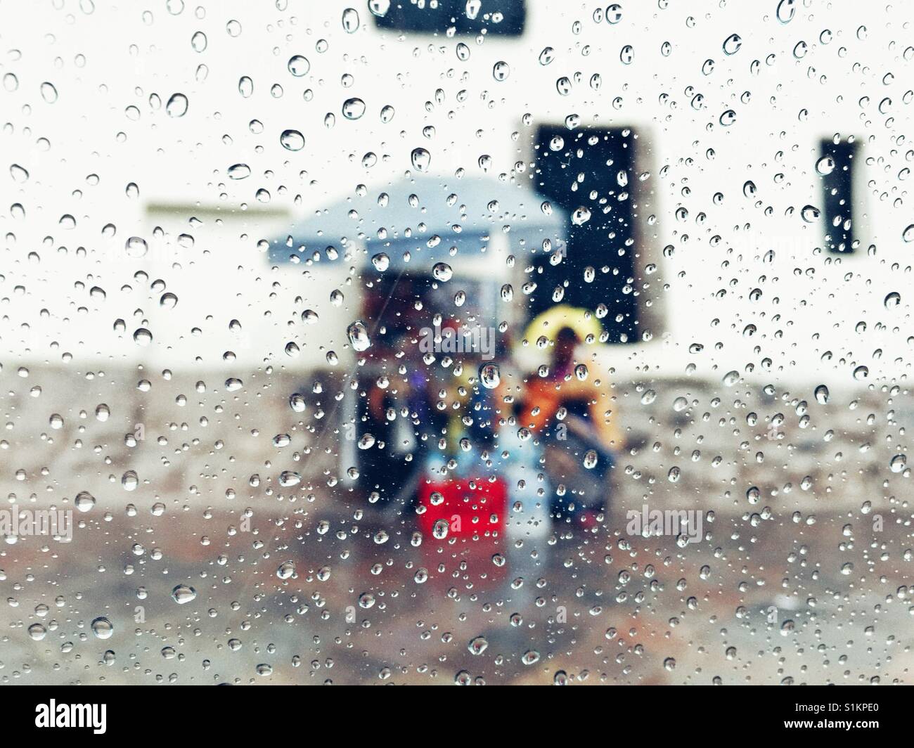 Les vendeurs de rue à travers les gouttes de pluie sous les parasols couverts en verre Cusco Pérou Banque D'Images