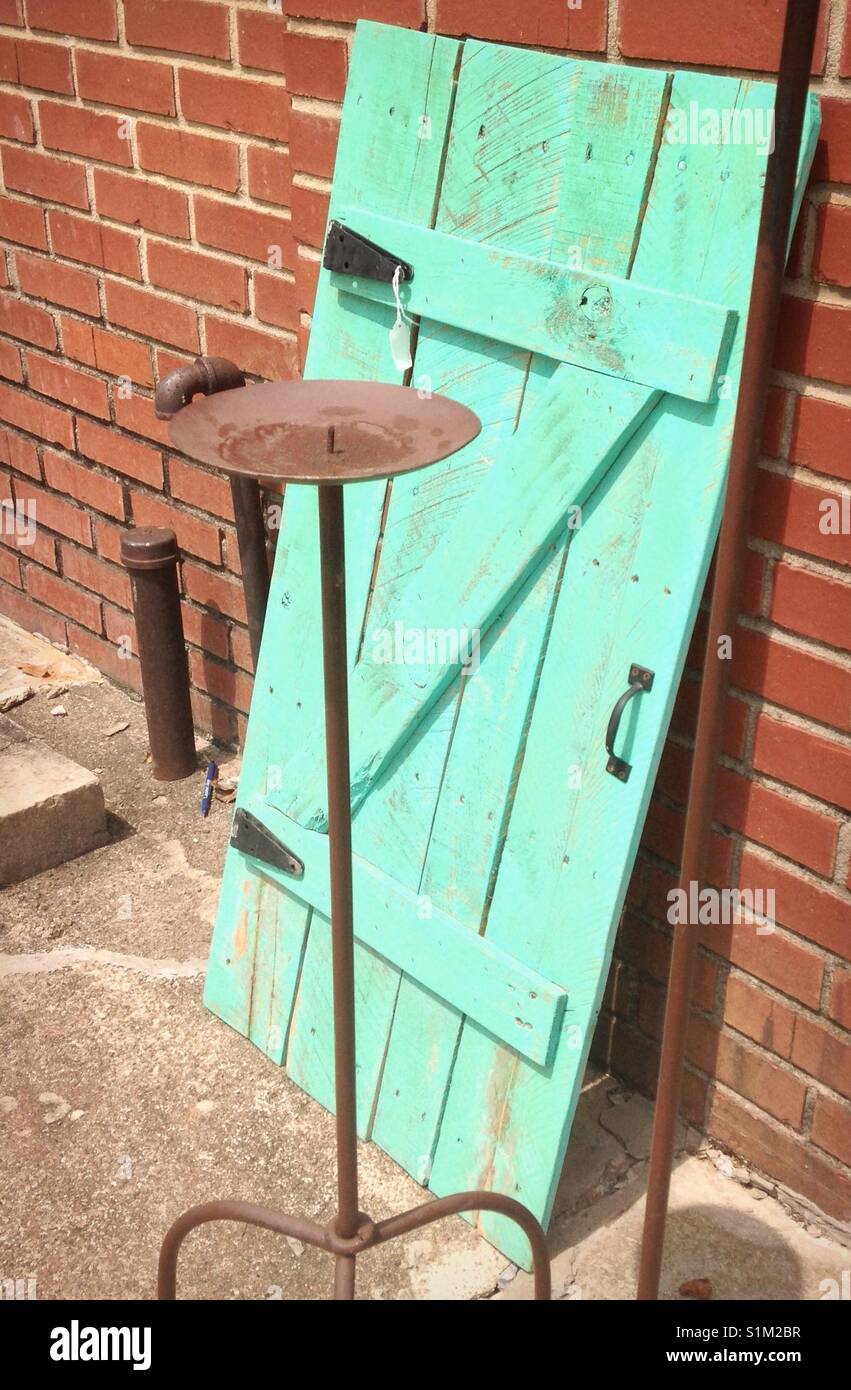 Aqua plein air porte appuyé contre le mur de brique derrière grand chandelier pilier en métal - Image de stock capturée avec un smartphone