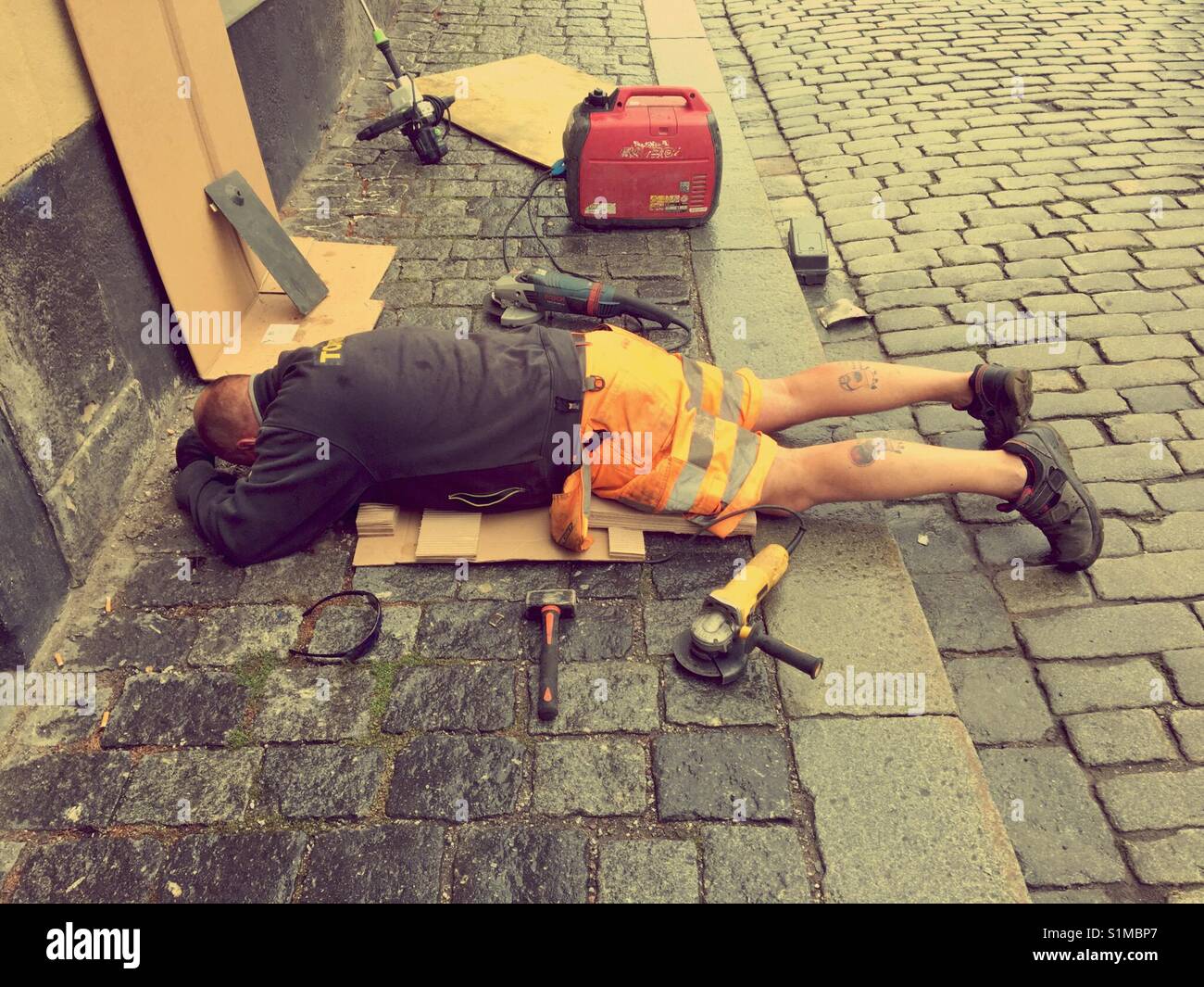 Entrepreneur Maintence allongé sur trottoir de vidange de fixation Banque D'Images