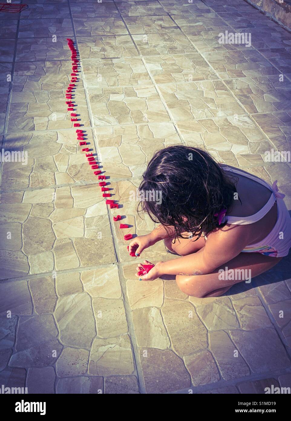 Petite fille jouant avec des lettres. Banque D'Images