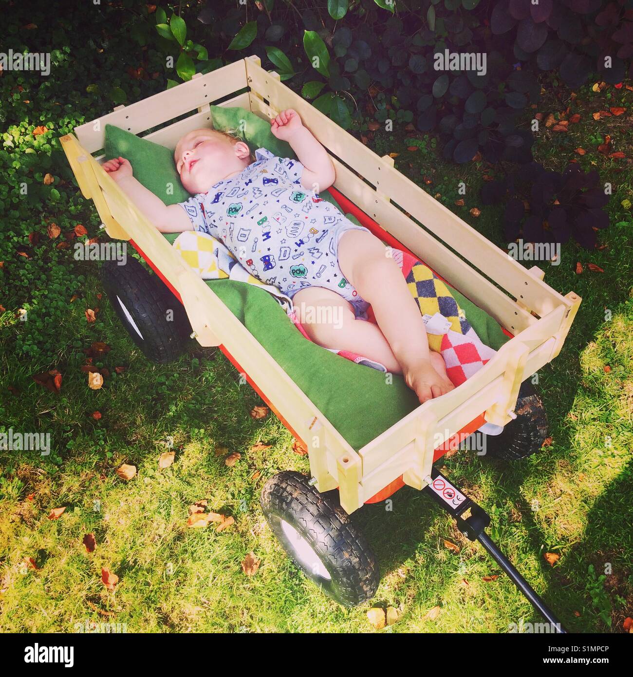 Un an bébé garçon endormi à l'arrière d'un chariot à main Banque D'Images