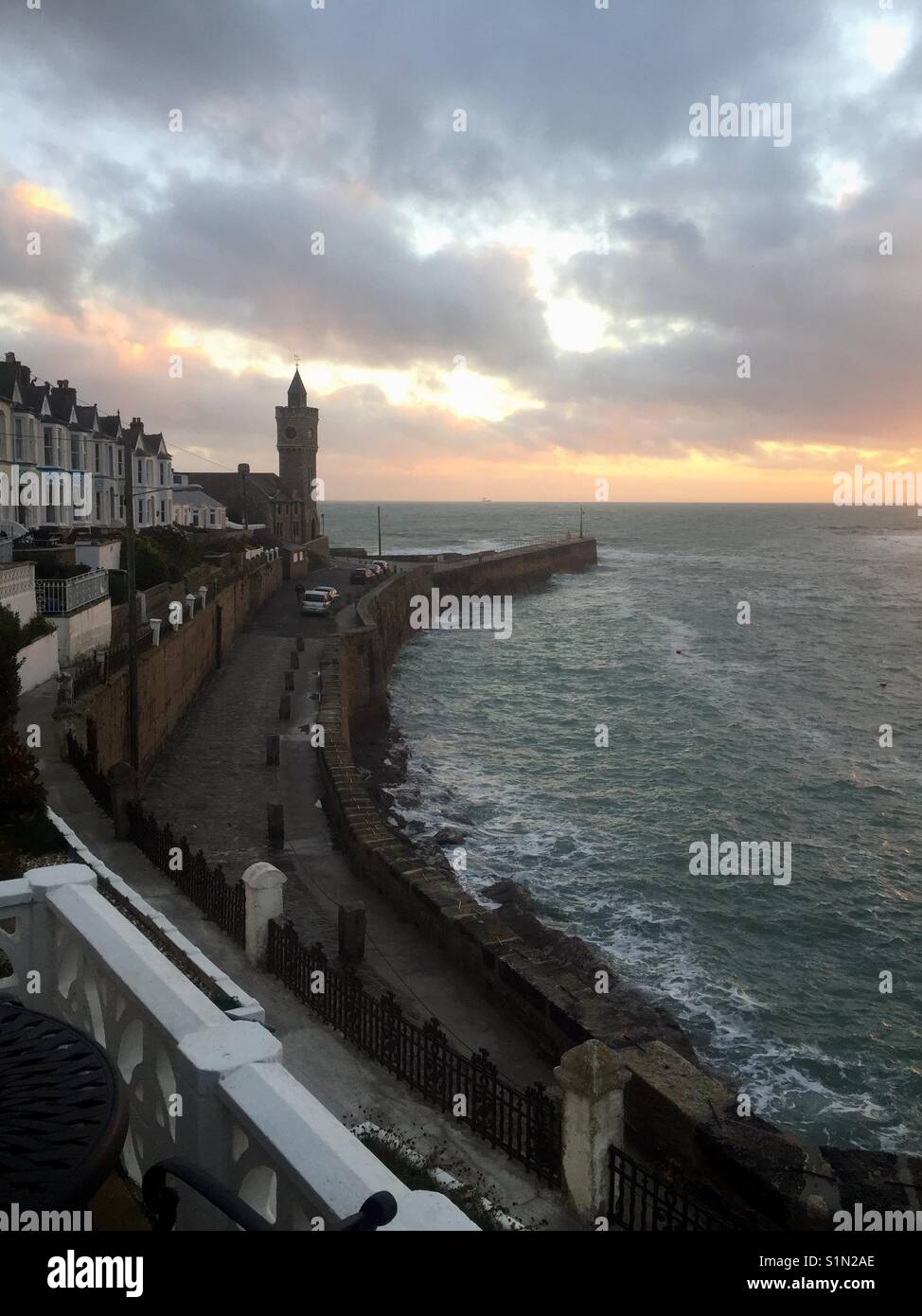 Portleven coucher du soleil hiver orageux montrant mur du port, l'Institut Bickford-Smith et terrasse avec vue sur la baie Banque D'Images