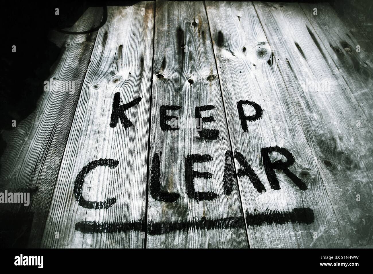 Peint sur un panneau d'avertissement sur une vieille porte en bois, de dire aux gens de rester à l'écart et de rester à l'écart. Banque D'Images