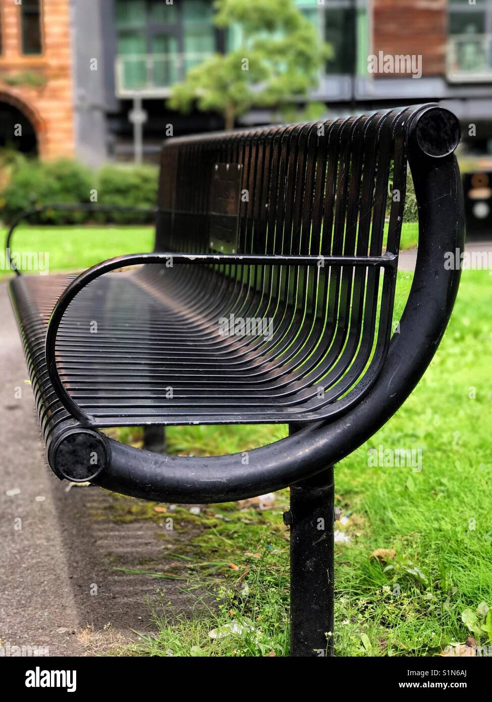 Les lignes et les courbes d'un black metal banc de parc Banque D'Images