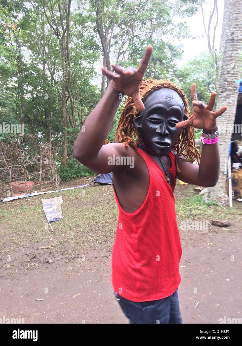 Participant avec des masques africains en 2017 Nyege Nyege music festival au bord du Nil, à Jinja, en Ouganda Banque D'Images