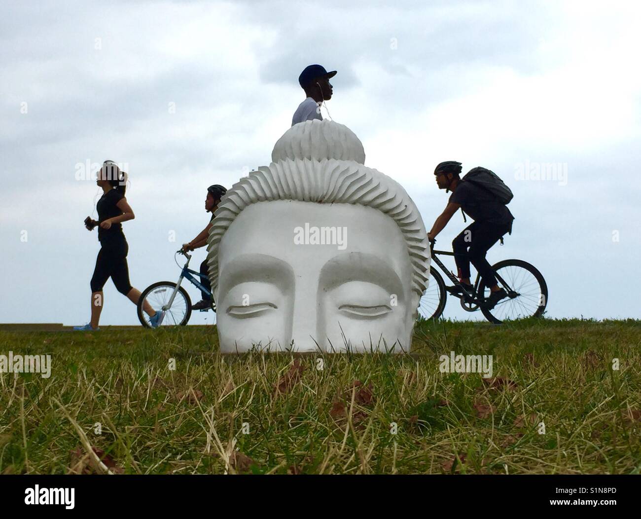 Les gens passent le Bouddha sculpture sur le sentier du bord du lac de Chicago. Indira Johnson a créé l'artiste sculptures Banque D'Images