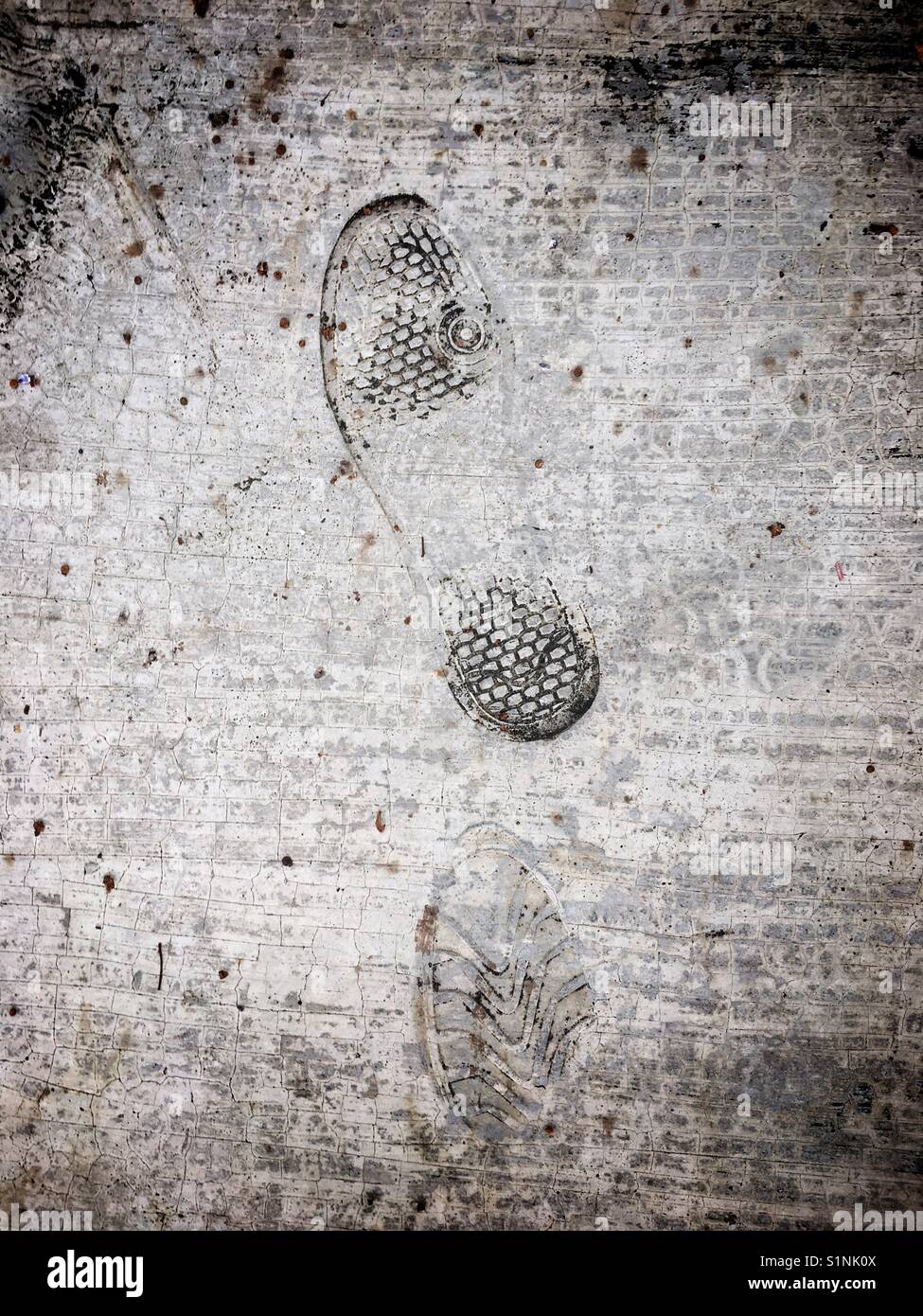 Un couple d'shoeprints impressionné sur trottoir de ciment Banque D'Images
