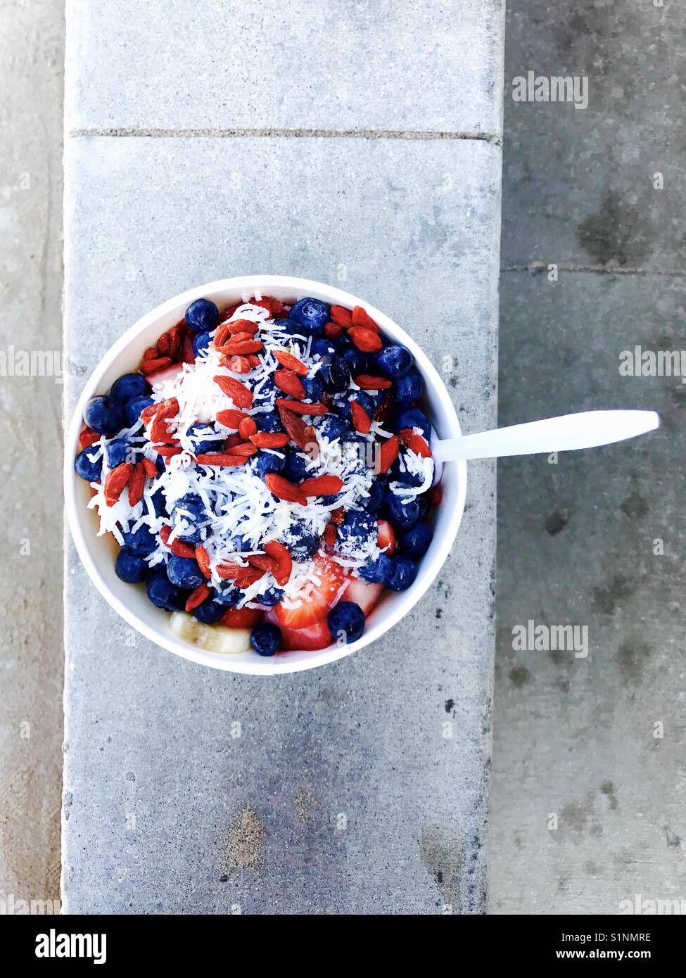 Un bol d'acai de bleuets, fraises, noix de coco et de copeaux. Banque D'Images
