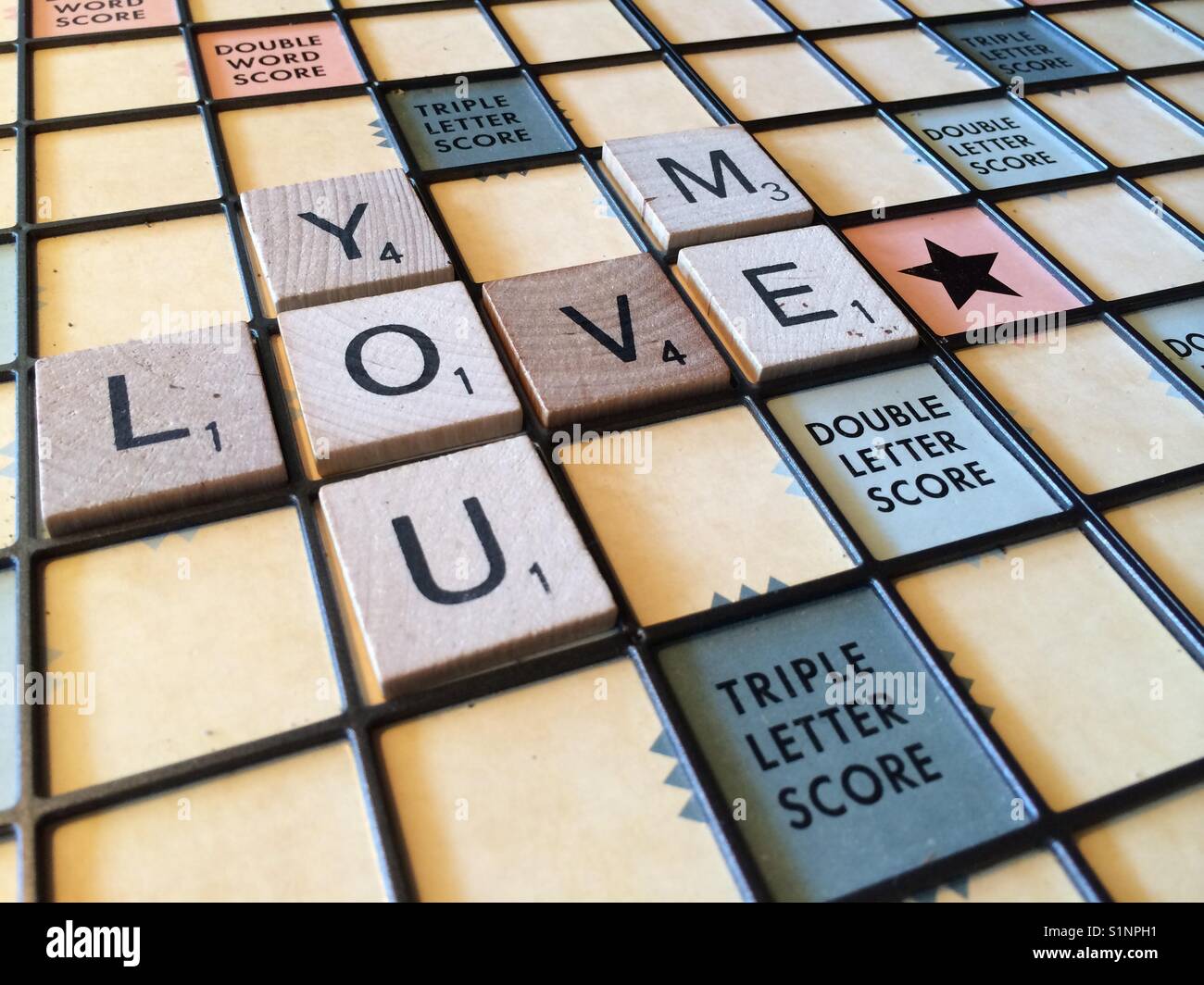 Les mots "vous m'aimez' sur un scrabble board Banque D'Images