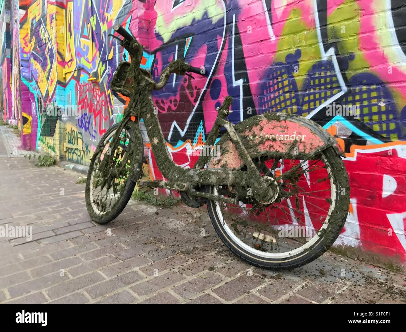 Abandonne Londres sale cycle location leaning against wall de graffitis après avoir été tiré de : canal - Image de stock capturée avec un smartphone