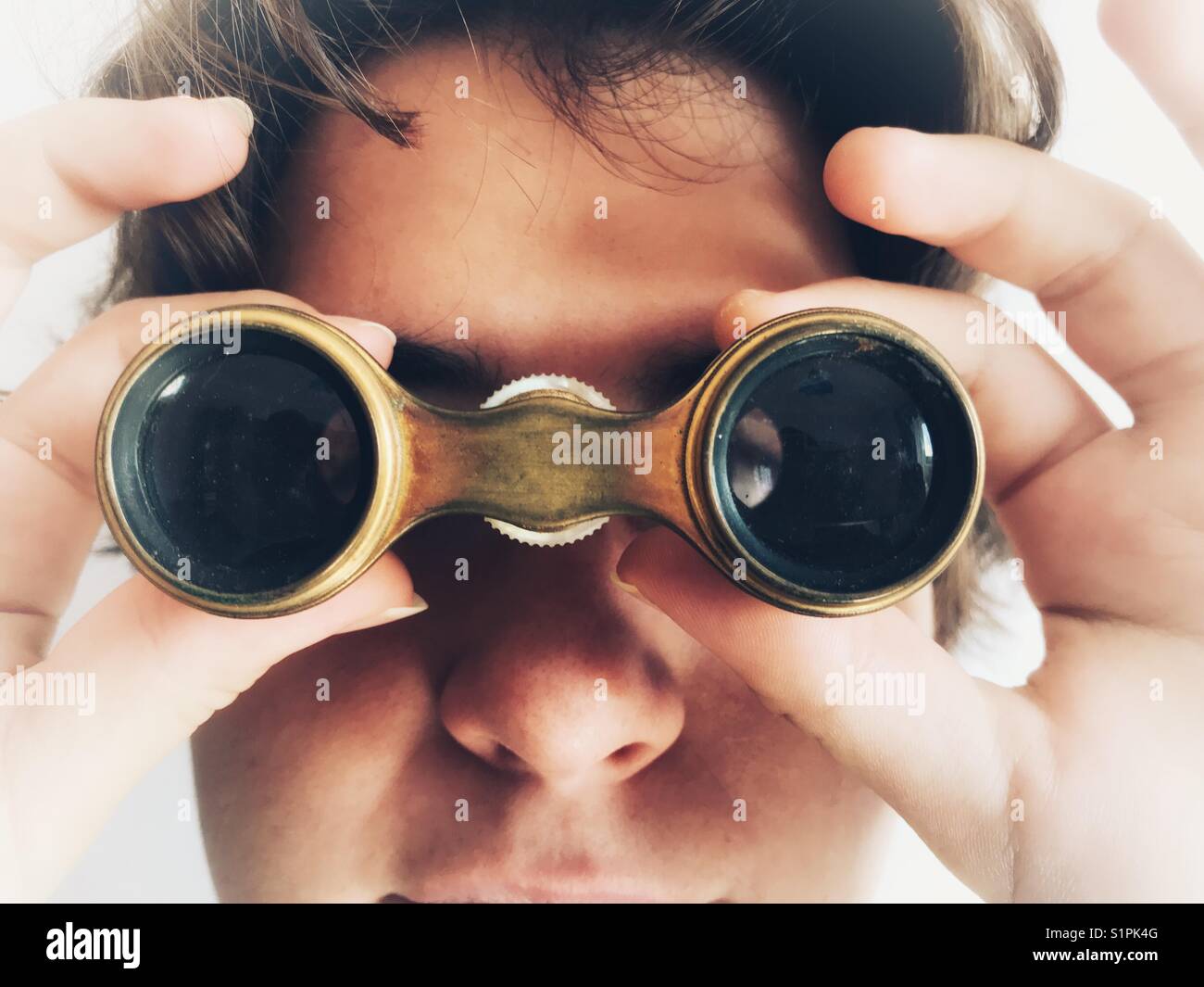 Femme millénaire regardant à travers une paire de lunettes d'opéra - Image de stock capturée avec un smartphone