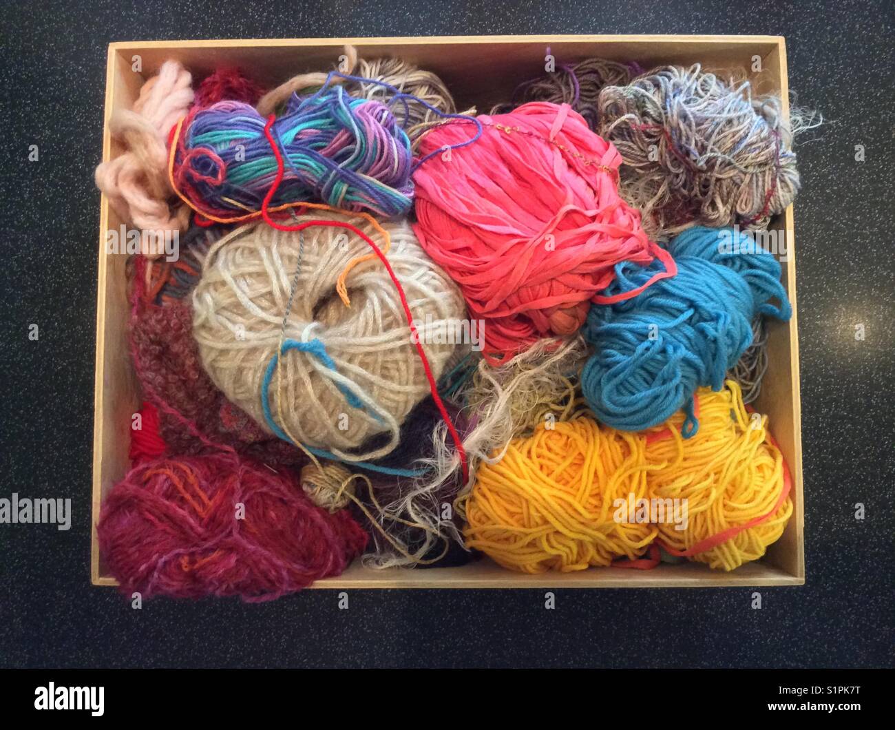 Boîte en bois avec collection de pelotes de laine Banque D'Images