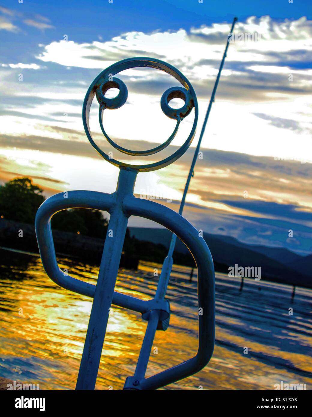 Acier peint Sculpture pêcheur au coucher du soleil, de la baie de Plaisance, Loch Lomond, Ecosse. Banque D'Images