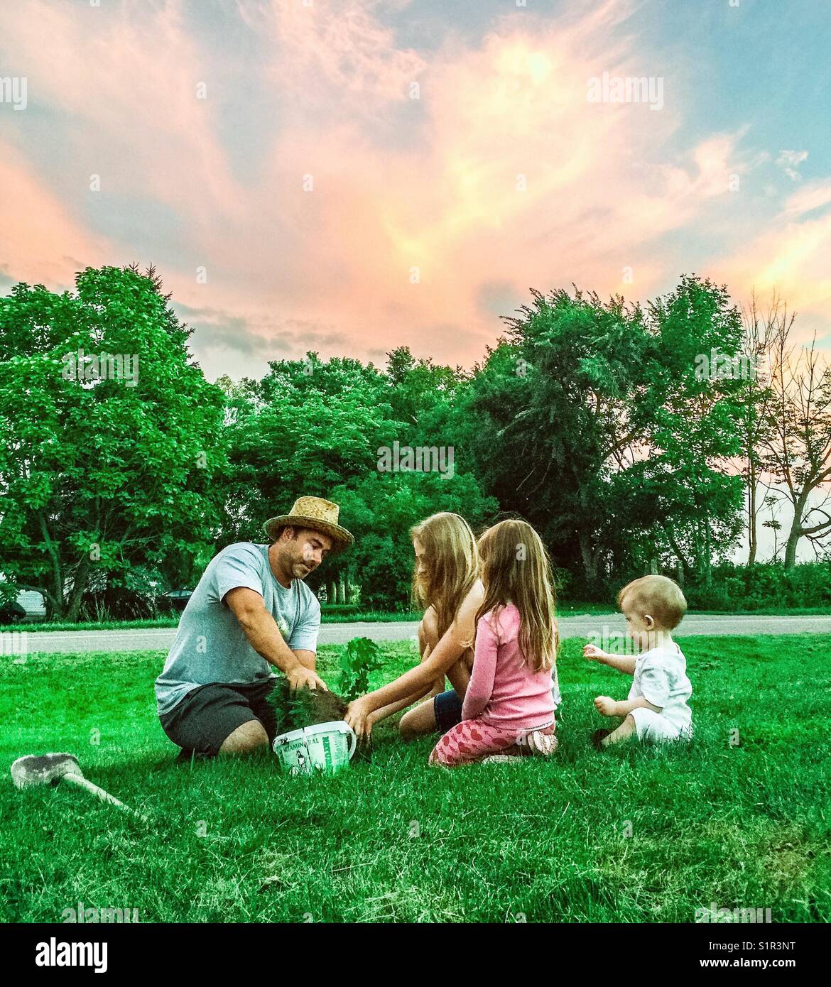 Père plantant un arbre avec ses filles - Image de stock capturée avec un smartphone