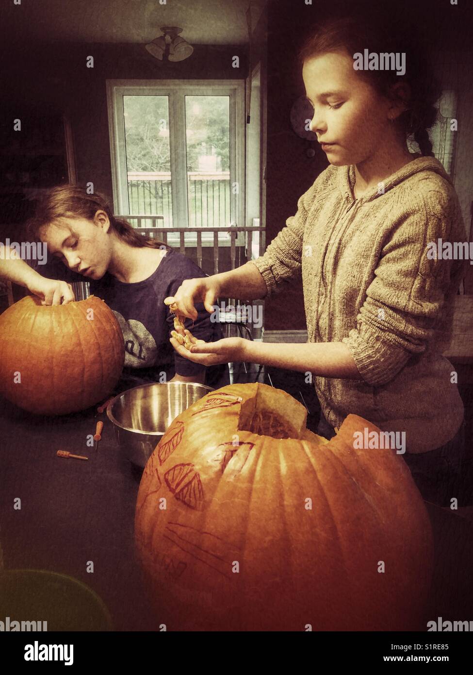 Deux filles sculptent des citrouilles d'Halloween en cric-o-lanternes Banque D'Images