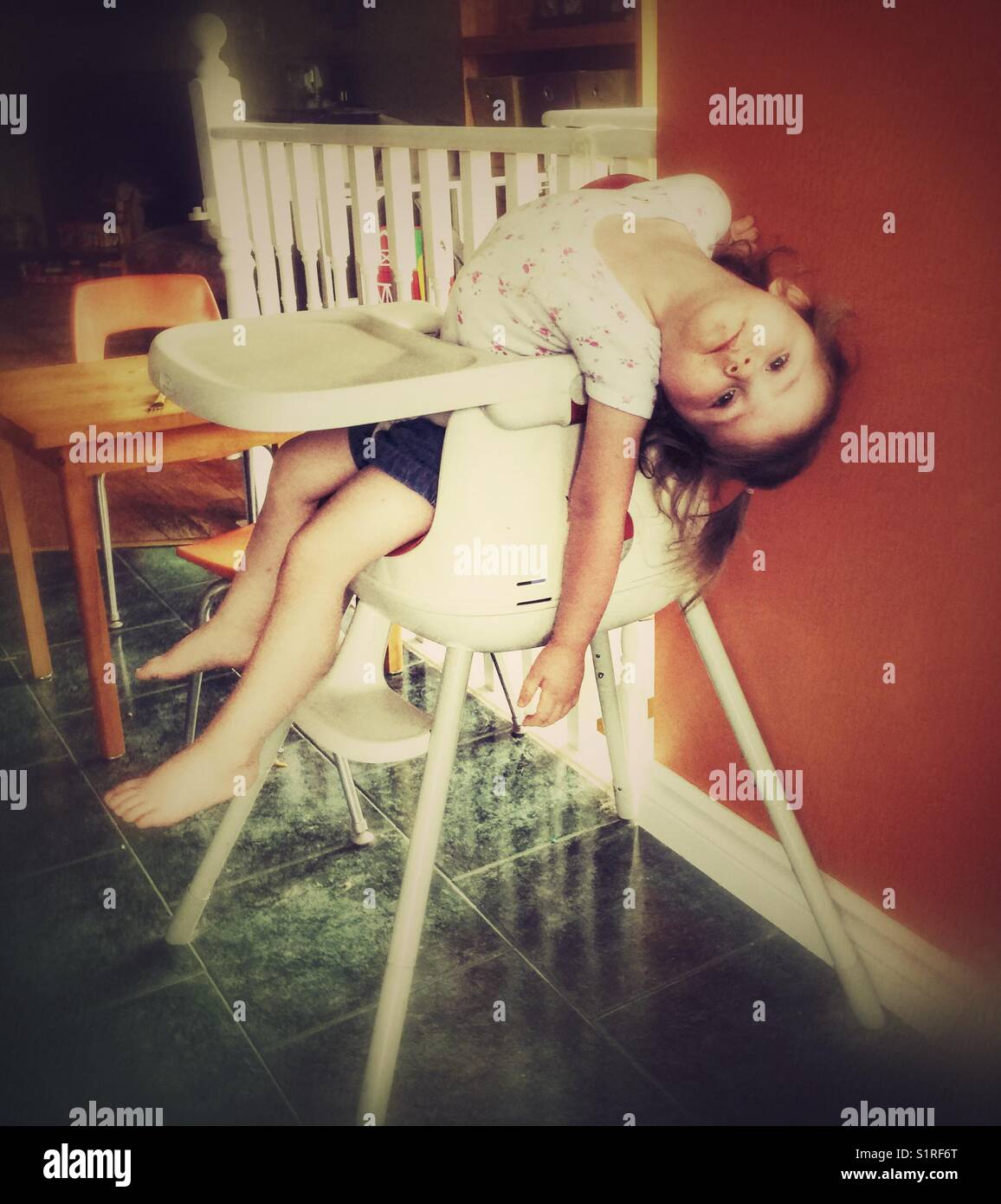 Bébé fille ennuie ferme dans sa chaise haute Banque D'Images