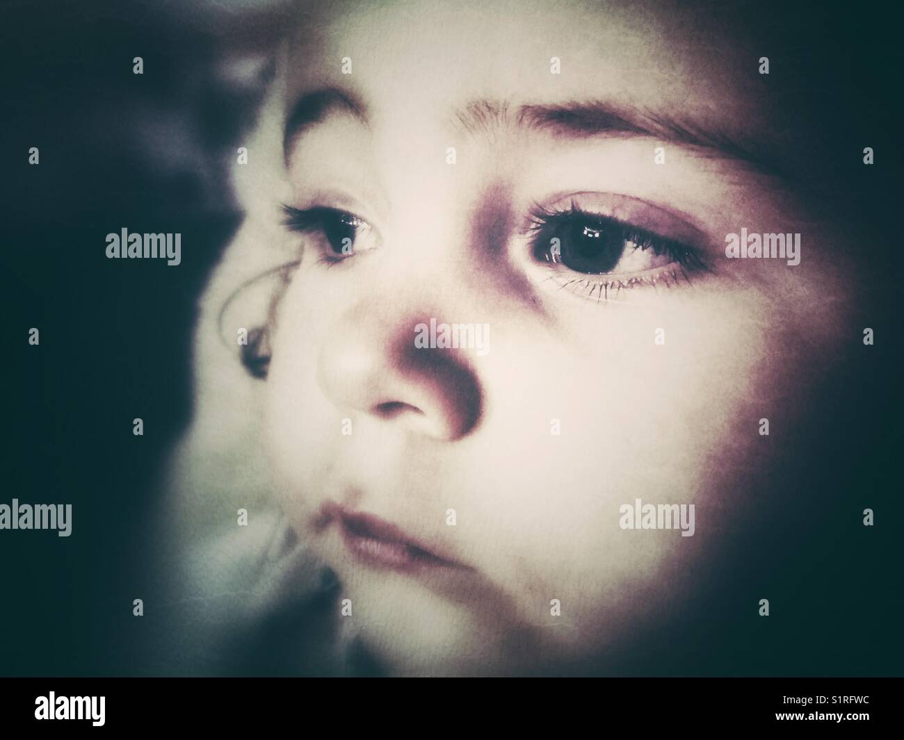 Moody gros plan d'un visage de deux ans regardant au loin Banque D'Images