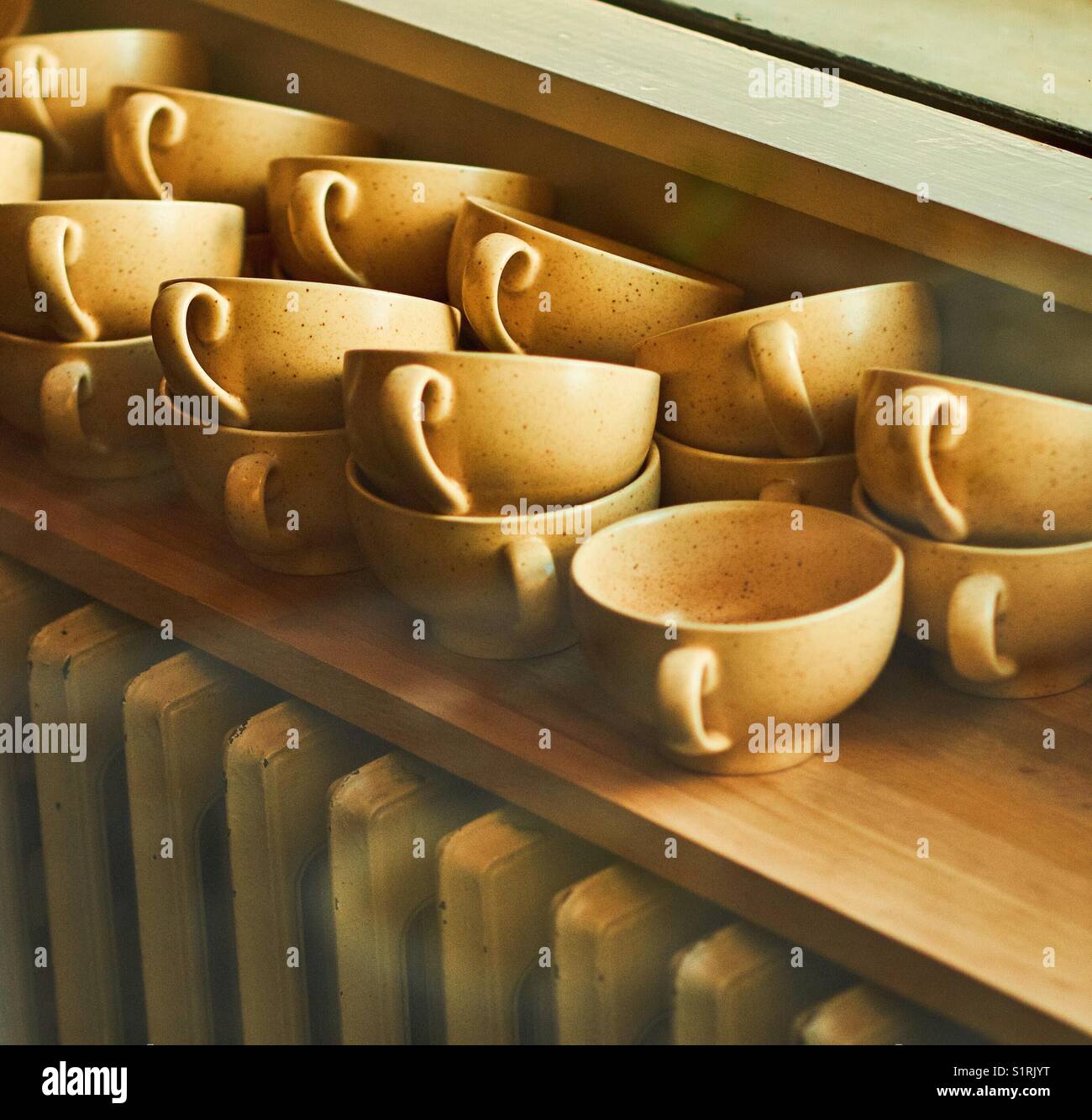 Une pile de tasses à café au-dessus d'un radiateur à l'ancienne Banque D'Images Une pile de tasses à café au-dessus d'un radiateur à l'ancienne Banque D'Images