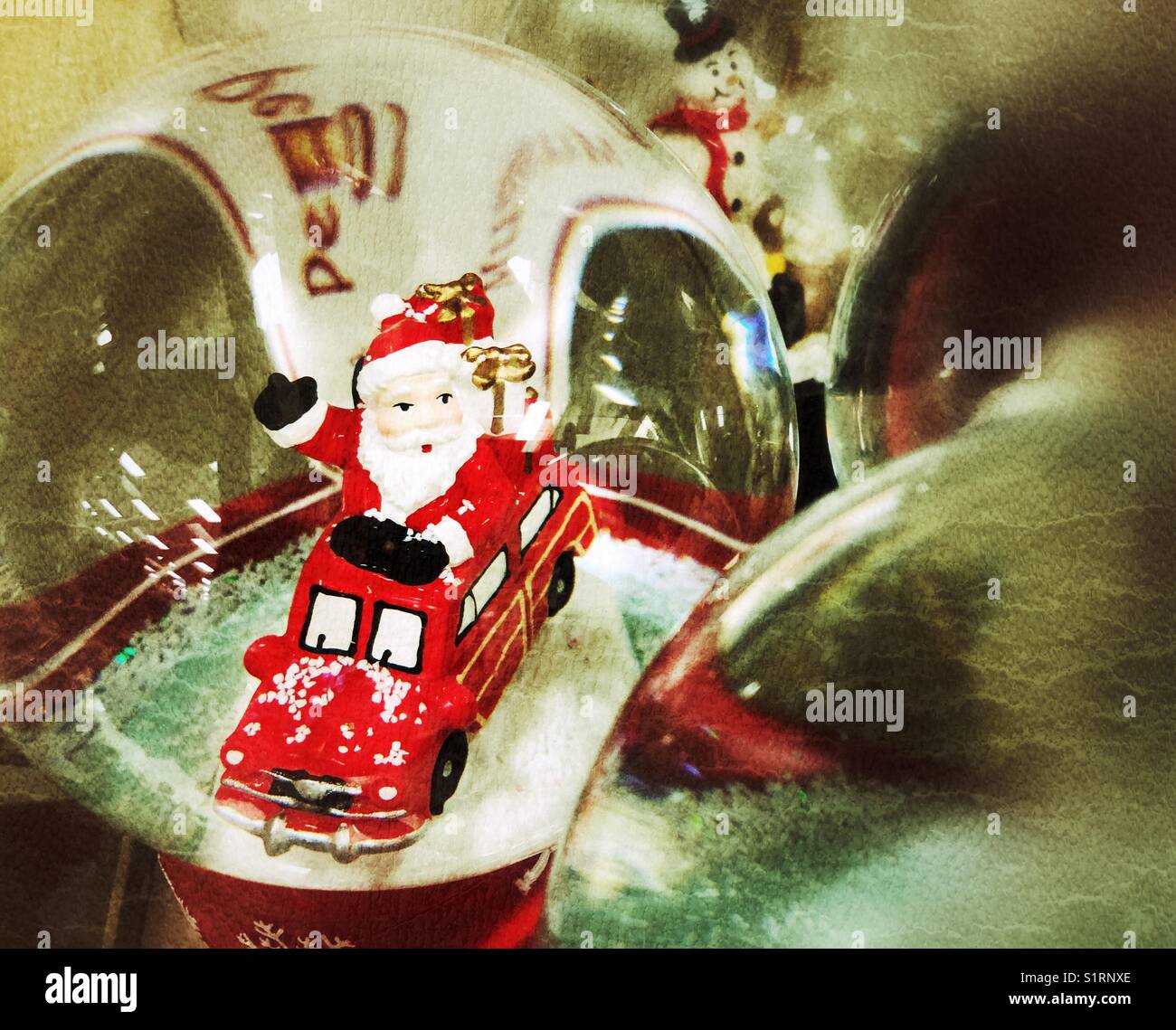 Le Père Noël dans un globe de neige au milieu d'autres globes de neige à thème de Noël dans un magasin exposé - Image de stock capturée avec un smartphone