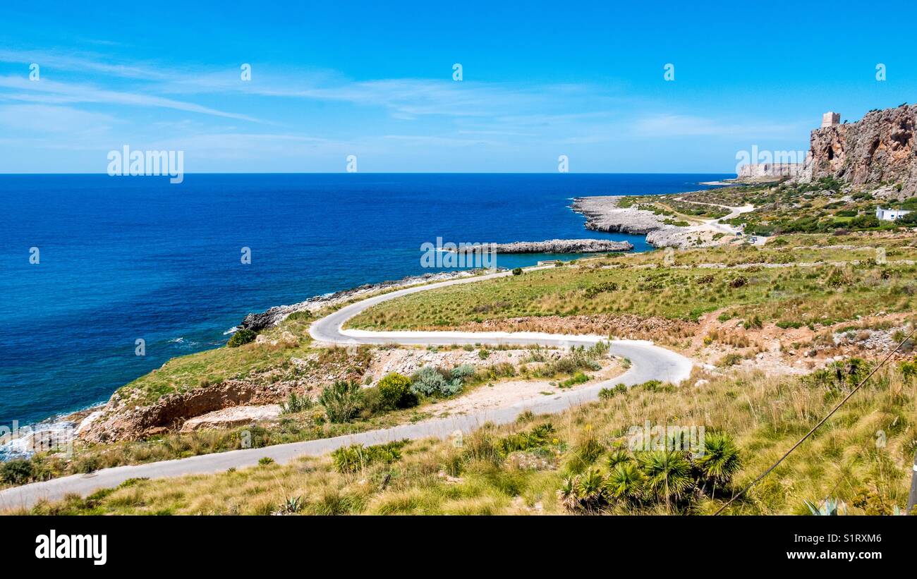 Route panoramique sur la mer méditerranée. côte sauvage avec des falaises et des champs verts contre un bleu profond de la mer, à San Vito lo Capo, Sicile, Italie Banque D'Images