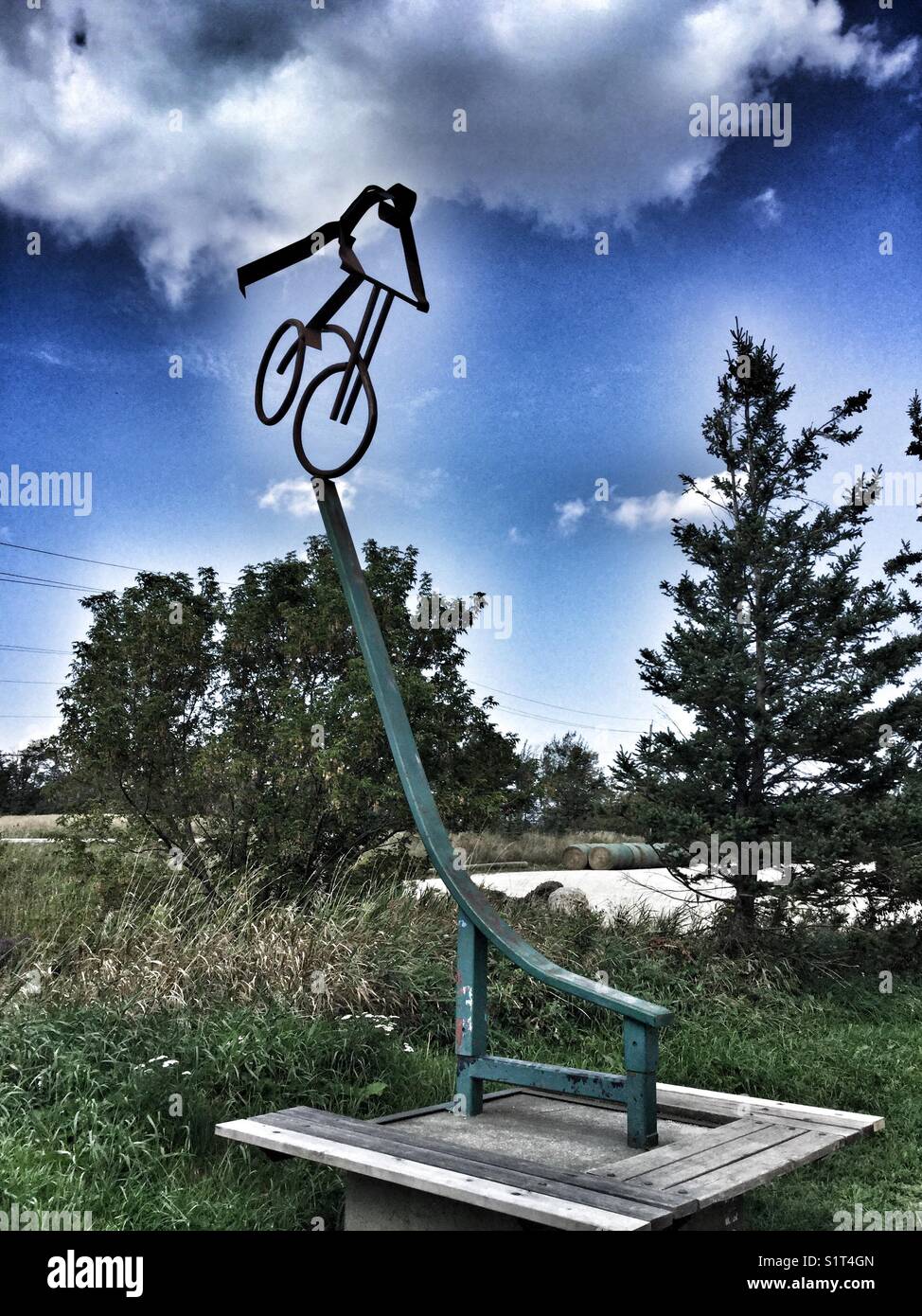 Sculpture d'un vélo de montagne équitation vers le bas d'une pente raide. Banque D'Images