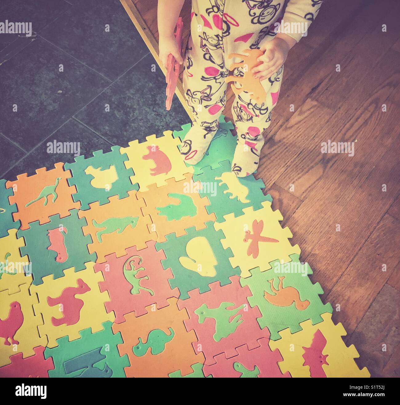Tout-petit enfant jouant avec de grands tapis puzzle en mousse Banque D'Images