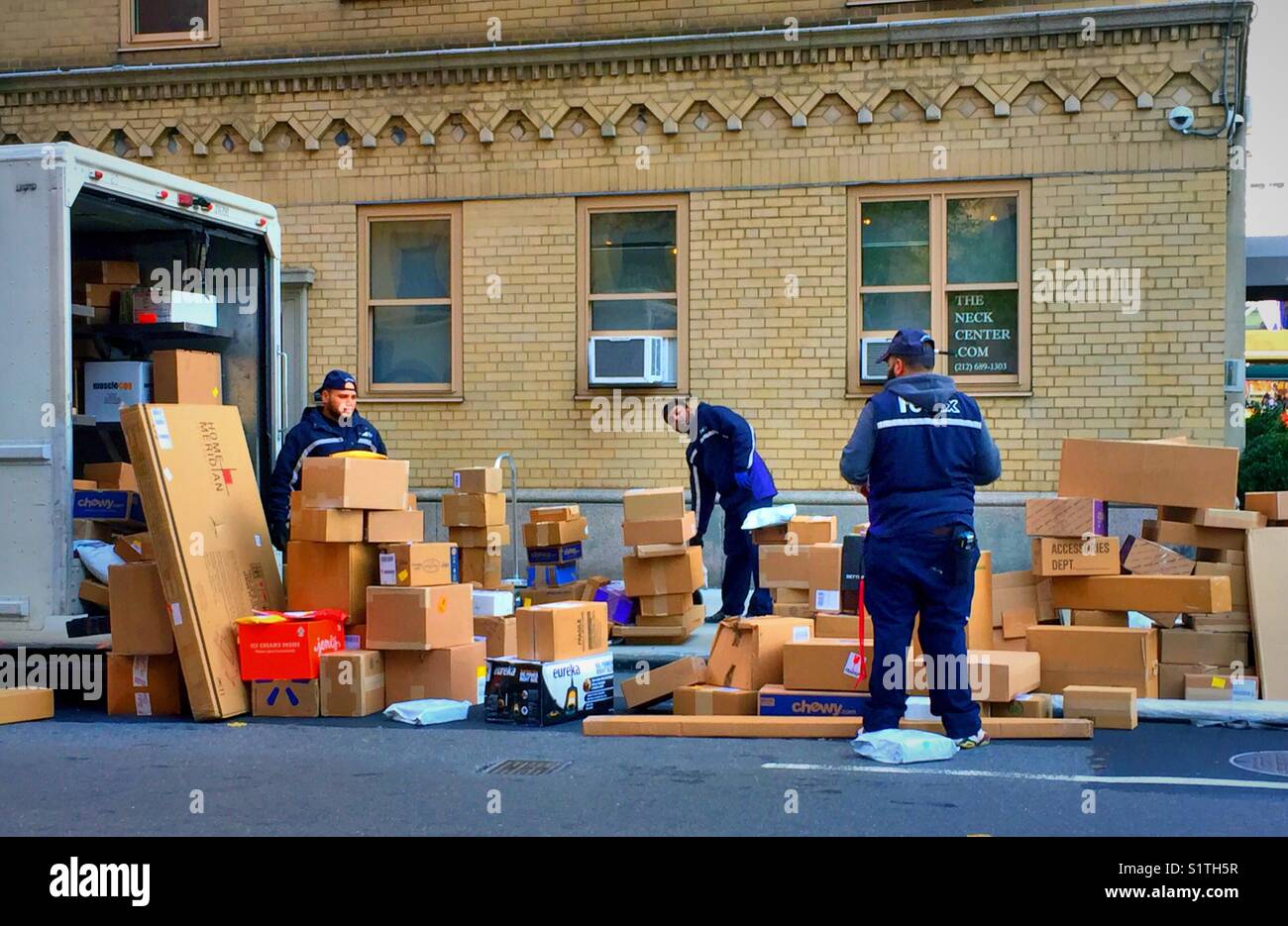 Colis de travailleurs et des boîtes d'un camion de FedEx en plein centre de New York au cours de la ruée de Noël, USA Banque D'Images