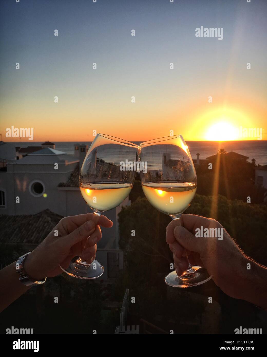 Deux verres à vin de trinquer ensemble au coucher du soleil. cheers ! Banque D'Images