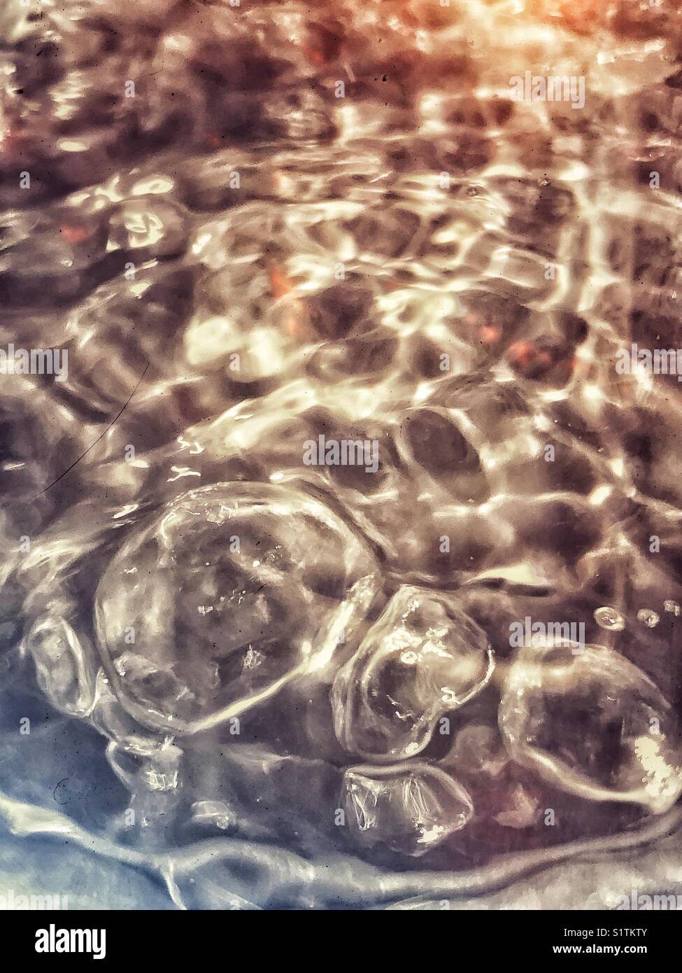Eau bouillante vue à travers une bouilloire en verre traitée de manière créative - Image de stock capturée avec un smartphone