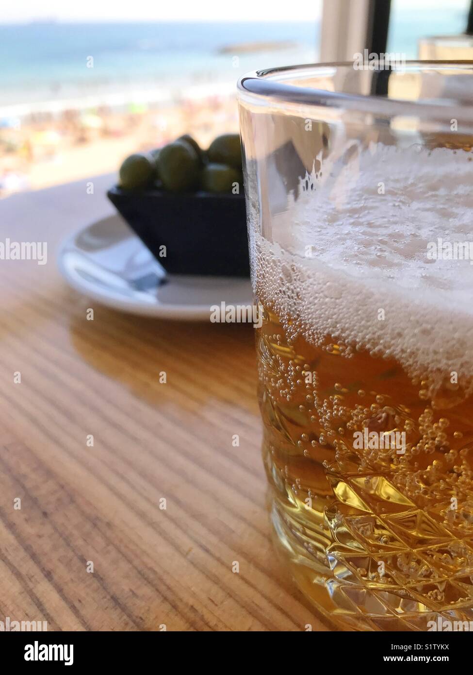 Verre de bière et les olives dans un bar de la plage. - Image de stock capturée avec un smartphone