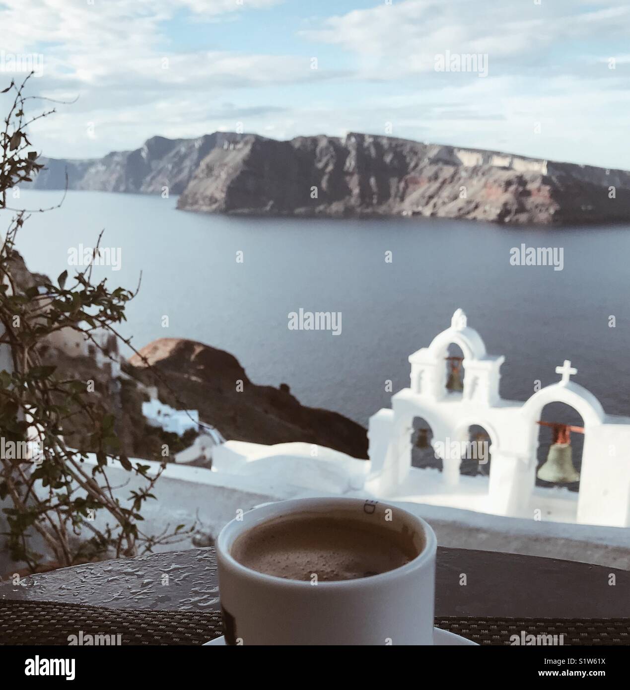 Tasse de café donnant sur l'église et de l'île de Néa Kaméni à Oia, Santorini Banque D'Images