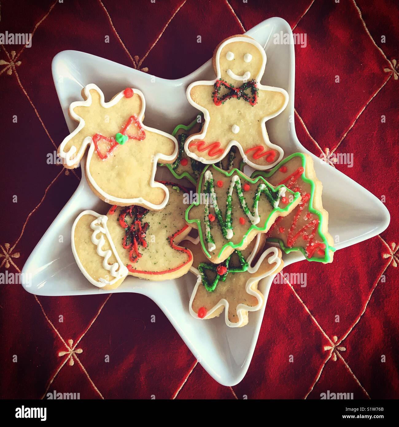 Décoration de fête biscuits de Noël en sucre sur une plaque en forme d'étoile sur fond rouge. Les carrés. - Image de stock capturée avec un smartphone