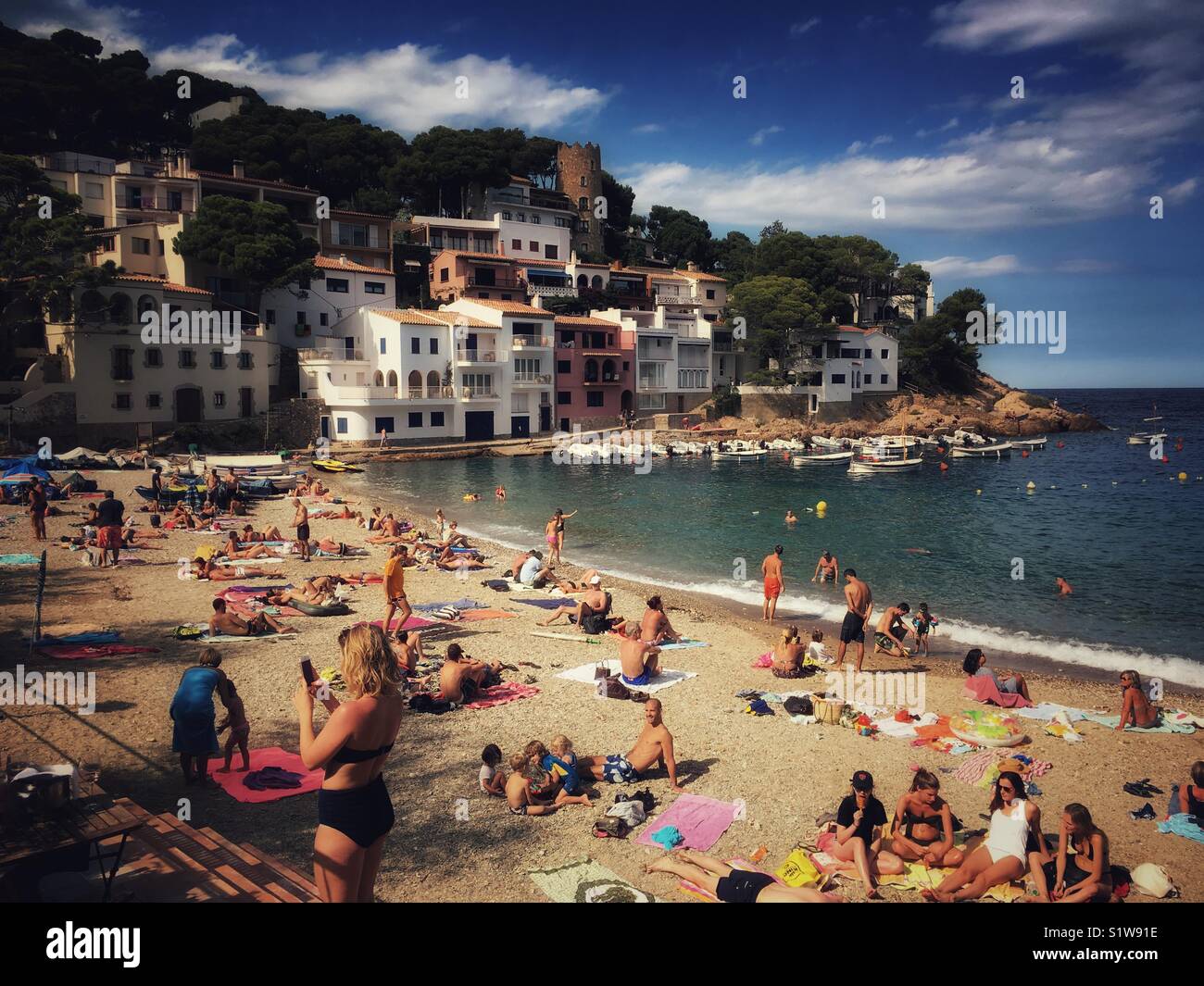 Aux personnes bénéficiant d'une journée d'été sur la plage de sable de Sa Tuna dans le Baix Emporda, région de Catalogne, Costa Brava, Espagne - Image de stock capturée avec un smartphone