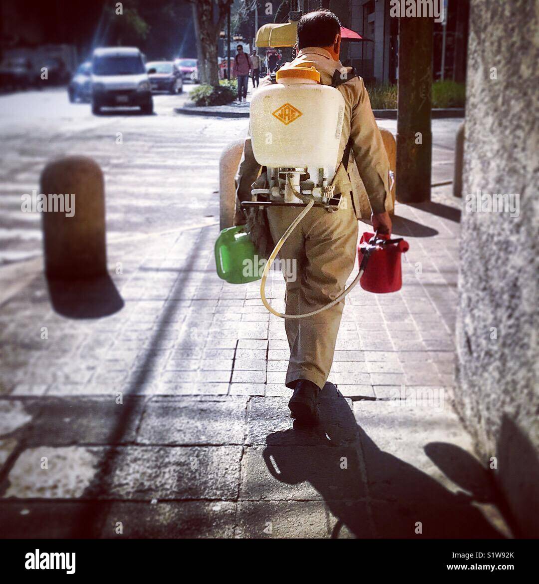 Un homme marche de poisons comme il fumigates dans une rue de Polanco, Mexico City, Mexico - Image de stock capturée avec un smartphone