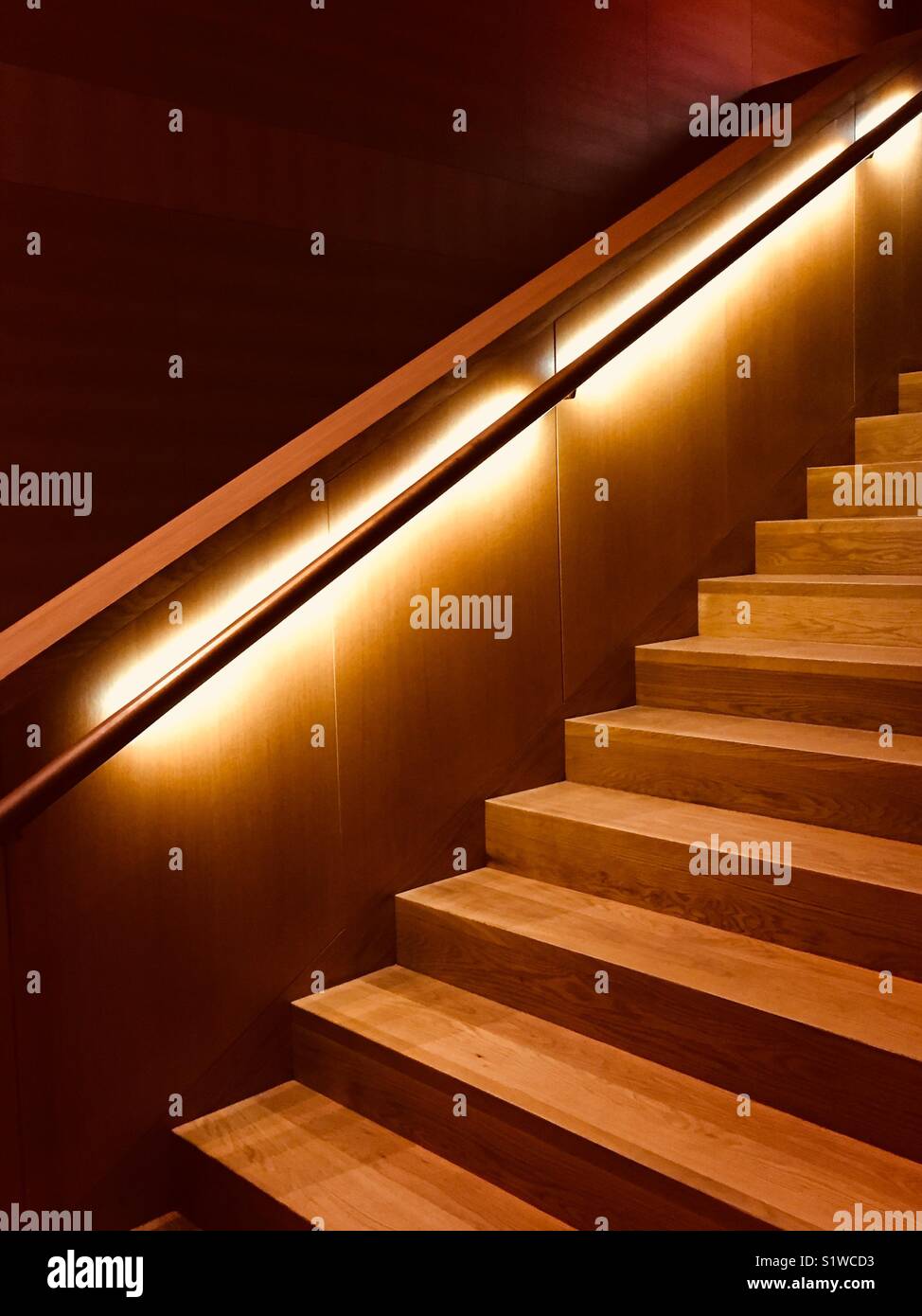 Escalier en bois avec rampe lumineuse. Escalier en chêne brun-rougeâtre. Banque D'Images